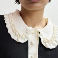 ESSENTIEL ANTWERP Polo en maille fine noir et blanc cassé à volants et perles